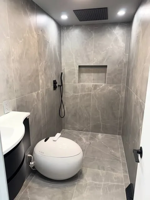 Curbless Walk In shower with gray porcelain tile and niche